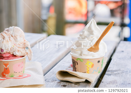 Summer cafe scene with soft serve ice cream and strawberry ice cream served in cute animal patterned cups 129792021