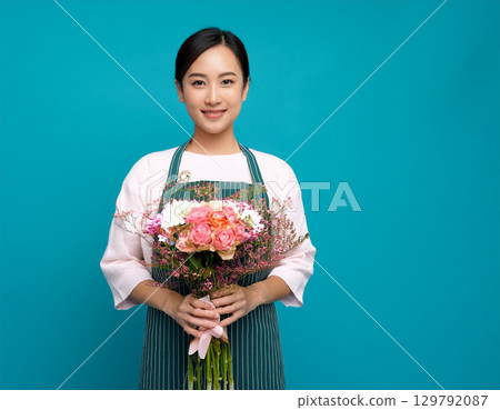身穿圍裙、手捧鮮花的女子 身穿圍裙、手捧鮮花的女子 129792087
