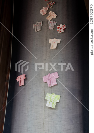 Miniature Japanese clothing displayed on a street corner 129792879