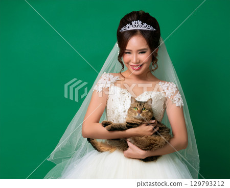 可愛的微笑女孩和穿著婚紗的貓看著相機 129793212