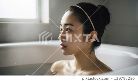 A young woman soaking in a bathtub 129793286