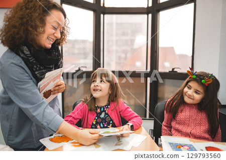 Female teacher helping elementary students at language school class 129793560