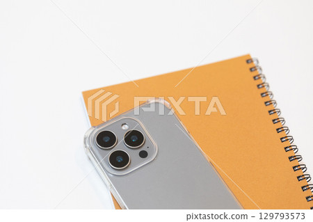 Image of a smartphone and notebook (stock photo) Image of a smartphone and notebook (stock photo) 129793573