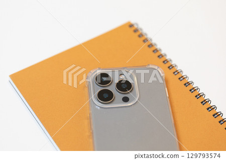 Image of a smartphone and notebook (stock photo) Image of a smartphone and notebook (stock photo) 129793574