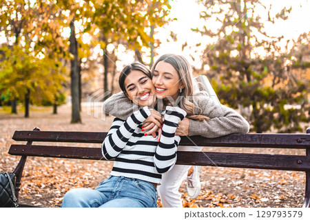 Two Women hugging on a Park Bench 129793579