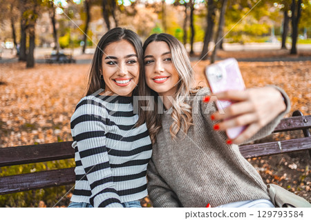 Two Women Taking a Picture With Their Cell Phone Two Women Taking a Picture With Their Cell Phone 129793584