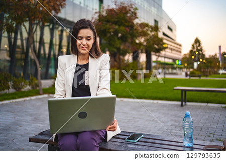 Businesswoman working on laptop outdoors 129793635