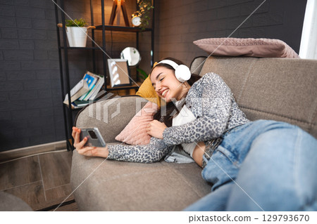 Relaxed young woman using mobile phone Relaxed young woman using mobile phone 129793670