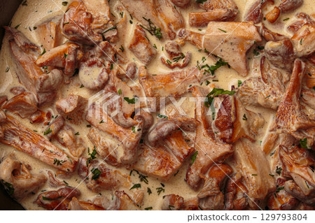 Chanterelle mushrooms frying in creamy sauce with dill and parsley close up top view Chanterelle mushrooms frying in creamy sauce with dill and parsley close up top view 129793804