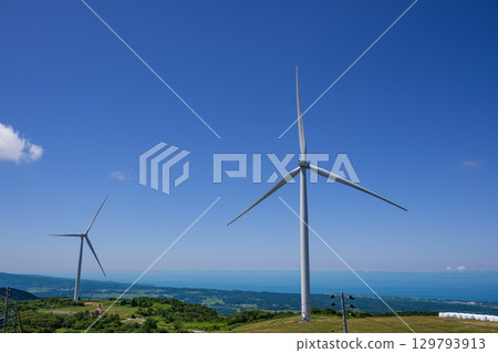 Wind turbines standing on a plateau with a view of the sea Wind turbines standing on a plateau with a view of the sea 129793913