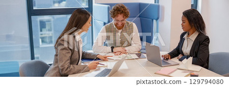 A Diverse Business Meeting Takes Place in a Modern Office Space Designed for Collaboration 129794080