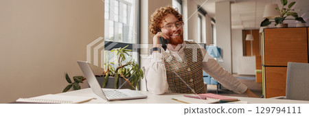 A cheerful, professional individual in a vibrant office setting, collaborating effectively 129794111