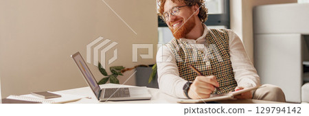 A Creative Professional Engaging in a Modern Office Environment, Cultivating Ideas and Collaboration 129794142