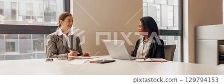A Collaborative Business Meeting Between Two Professionals Taking Place in a Modern Office Space A Collaborative Business Meeting Between Two Professionals Taking Place in a Modern Office Space 129794153