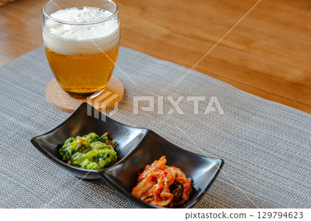 A homely evening meal with beer and snacks like kimchi and green vegetables A homely evening meal with beer and snacks like kimchi and green vegetables 129794623