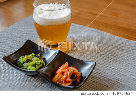 A homely evening meal with beer and snacks like kimchi and green vegetables A homely evening meal with beer and snacks like kimchi and green vegetables 129794624