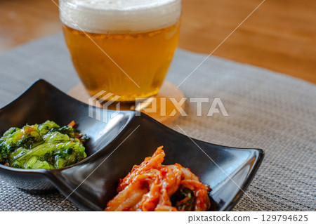 A homely evening meal with beer and snacks like kimchi and green vegetables A homely evening meal with beer and snacks like kimchi and green vegetables 129794625