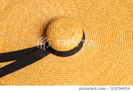 Large straw hat with black ribbon detail, perfect for summer 129794854