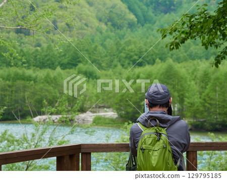 Tourists enjoying the scenery of Taisho Pond, a popular summer tourist spot in Kamikochi Tourists enjoying the scenery of Taisho Pond, a popular summer tourist spot in Kamikochi 129795185