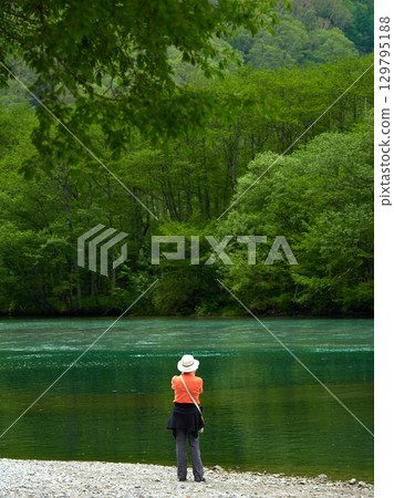 Tourists enjoying the scenery of Taisho Pond, a popular summer tourist spot in Kamikochi Tourists enjoying the scenery of Taisho Pond, a popular summer tourist spot in Kamikochi 129795188