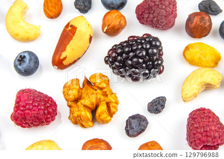 Colorful assortment of fresh fruits and nuts arranged on a white background 129796988