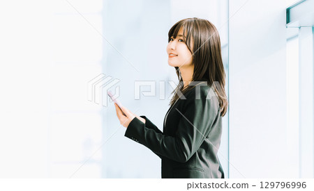Smiling woman/businesswoman using a smartphone Smiling woman/businesswoman using a smartphone 129796996