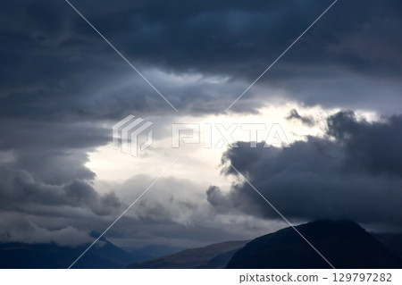 Dramatic sky over rugged mountains in Iceland during an overcast day 129797282