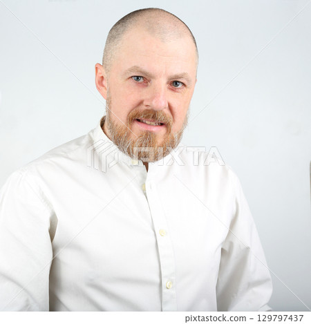 Professional man with a beard wearing a white shirt poses confidently for a portrait Professional man with a beard wearing a white shirt poses confidently for a portrait 129797437