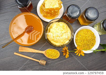 Natural honey, beeswax, and pollen collection with various products on wooden table 129797459