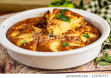 Lush apple dessert in the oven aroma of cinnamon and vanilla Lush apple dessert in the oven aroma of cinnamon and vanilla 129797777