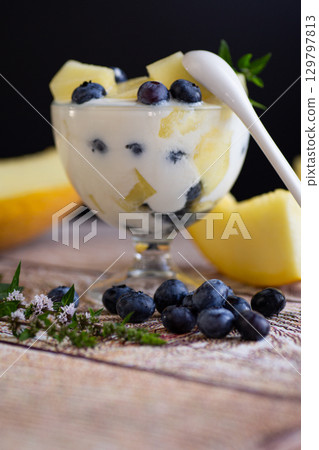 Summer vitamin cream yogurt with melon blueberries on a wooden Summer vitamin cream yogurt with melon blueberries on a wooden 129797813