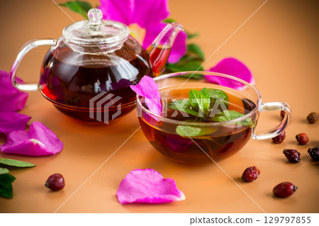 Aromatic natural drink with rosehip petals and fruits and a sprig of mint 129797855