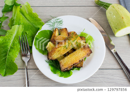 Fried zucchini slices with salad greens Fried zucchini slices with salad greens 129797856