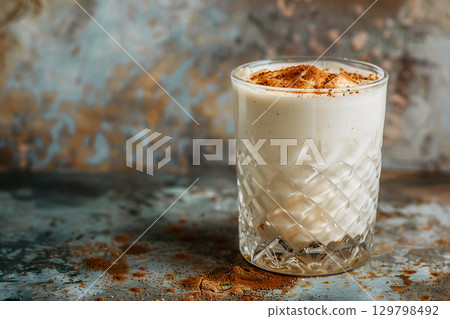 Refreshing glass of creamy horchata with cinnamon on a rustic background. 129798492