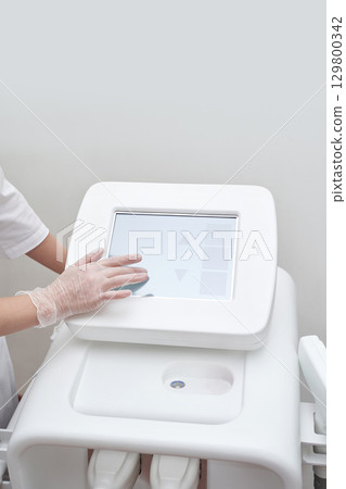 Female medical professional using advanced touchscreen medical device 129800342