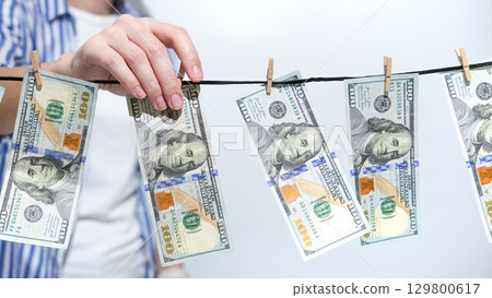 Money Laundering Concept with US Currency on Clothesline. Illegal Finance, Corruption, and Crime. Money Laundering Concept with US Currency on Clothesline. Illegal Finance, Corruption, and Crime. 129800617