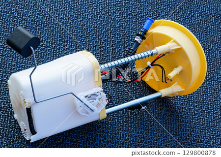 Automotive fuel pump module with wiring and float sensor on textured black background Automotive fuel pump module with wiring and float sensor on textured black background 129800878