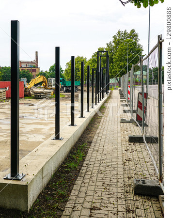 New Fence Construction Along Sidewalk at Urban Worksite 129800888