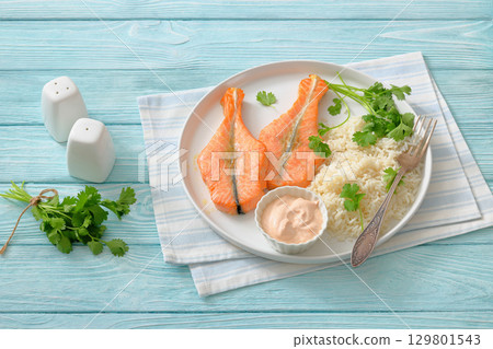 baked salmon steaks with rice, cilantro and sauce baked salmon steaks with rice, cilantro and sauce 129801543