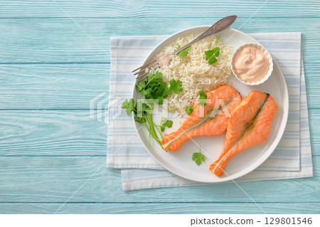 baked salmon steaks with rice, cilantro and sauce baked salmon steaks with rice, cilantro and sauce 129801546