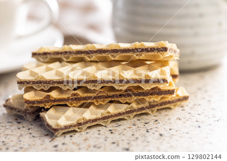 Sweet crispy wafers on kitchen table. Sweet crispy wafers on kitchen table. 129802144