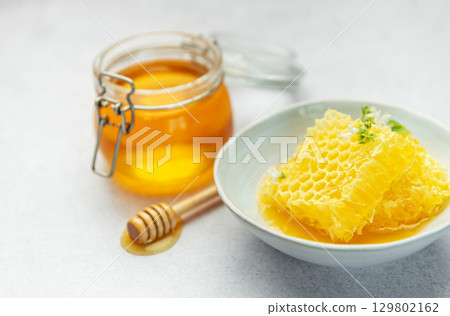 Honey, honeycomb and bee pollen creating delicious golden composition 129802162