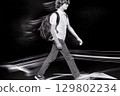 Student walking fast at night with motion blur effect 129802234