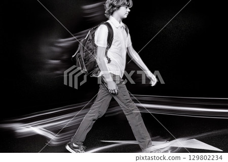 Student walking fast at night with motion blur effect 129802234