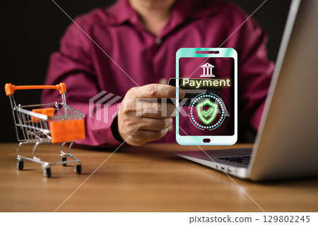 businessman makes a secure online payment using a credit card and a futuristic digital interface on a smartphone, symbol e-commerce, financial technology, and digital transactions for modern shopping. 129802245