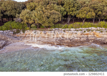 Rocky coastline with clear turquoise water in Istria, Croatia. 129802411