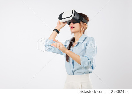 Happy woman with vr headset glasses virtual reality experience asian game, touching screen businesswoman exploring digital future with advanced vr tech, isolated studio white background Happy woman with vr headset glasses virtual reality experience asian game, touching screen businesswoman exploring digital future with advanced vr tech, isolated studio white background 129802424