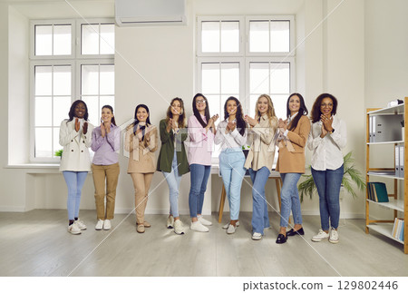Group of happy smiling business women looking at the camera and clapping hands. 129802446