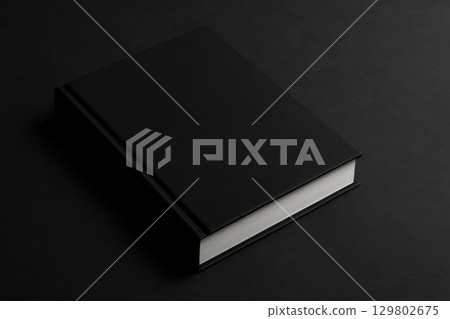 Black hardcover book with white pages on dark surface, minimalistic style, clean and elegant design, perfect for publishing or branding projects 129802675