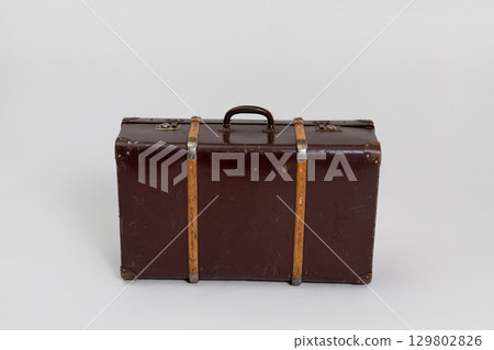 An exquisite Vintage Brown Suitcase adorned with Wooden Straps for stylish travel adventures 129802826